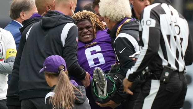 Minnesota Vikings safety Lewis Cine (6) grimaces as he receives treatment after an injury during an NFL match between Minnesota Vikings and New Orleans Saints at the Tottenham Hotspur stadium in London, Sunday, Oct. 2, 2022.